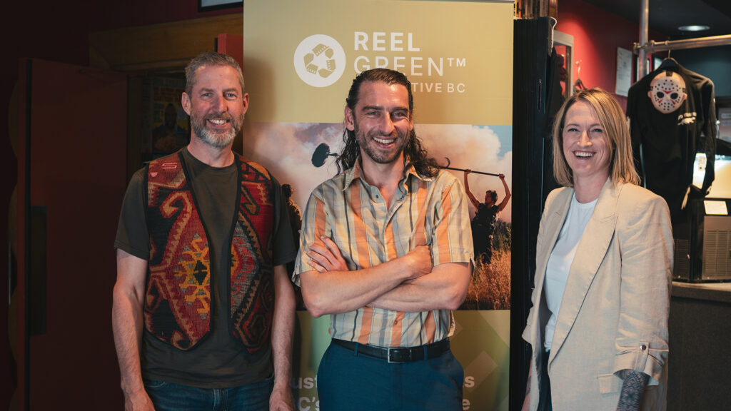 Three people stand together.